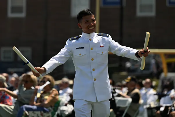 A Coast Guard cadet walks across the stage during the academy's graduation ceremony in New London, Connecticut.